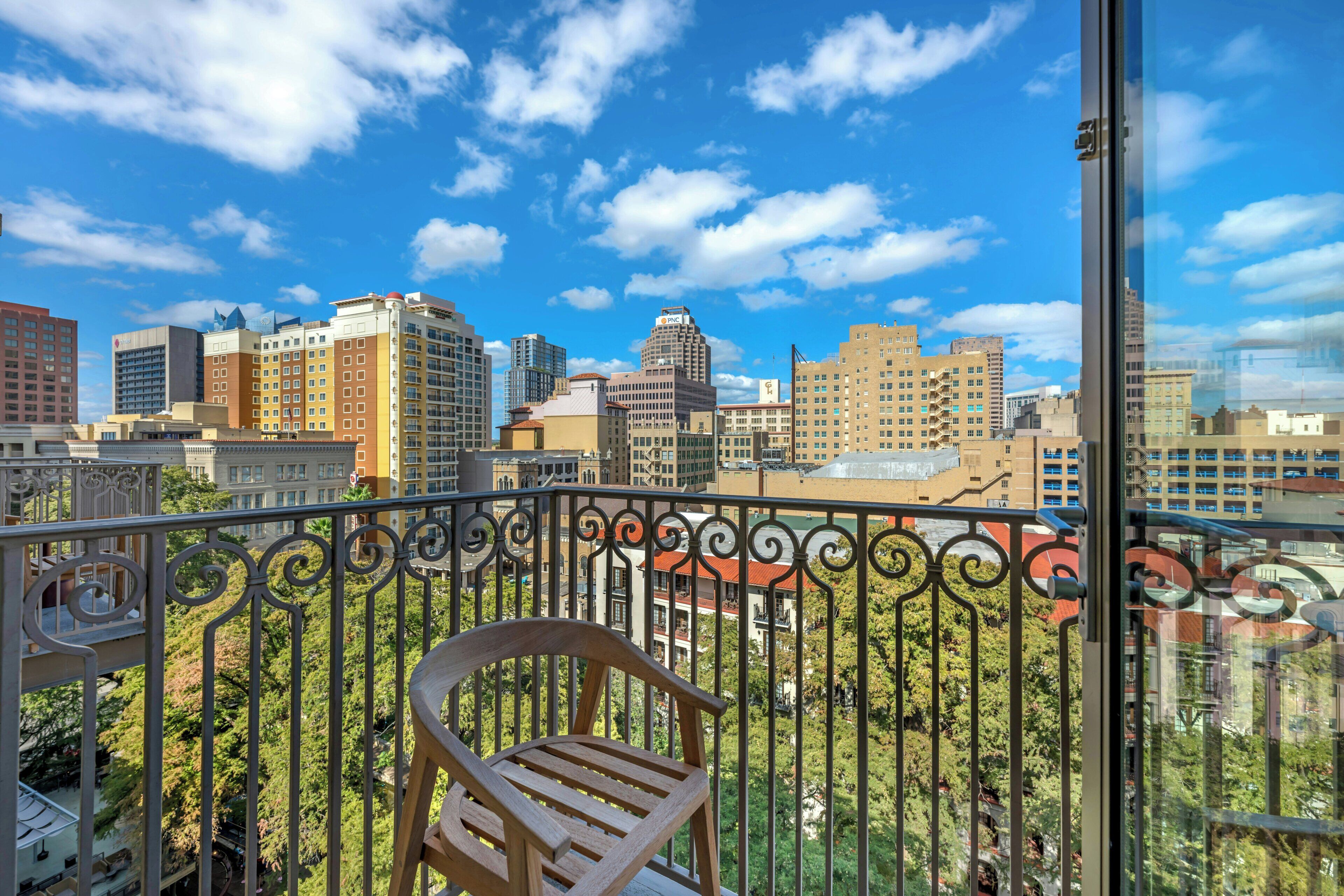 Un balcon offrant une vue sur le paysage urbain, avec différents bâtiments et un ciel dégagé.