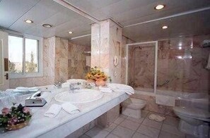 Habitación triple Deluxe, balcón | Baño | Ducha y bañera combinadas y bañera de hidromasaje