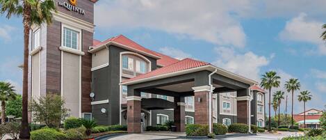 A hotel with a modern design, featuring a prominent entrance and a covered area.