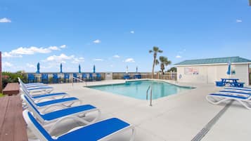 Una piscina techada, una piscina al aire libre, sombrillas