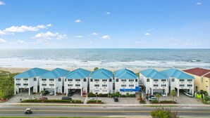 A beachfront hotel with multiple buildings, each featuring a blue roof and white walls.