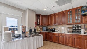 A kitchen with wooden cabinets, a buffet table, and various appliances.