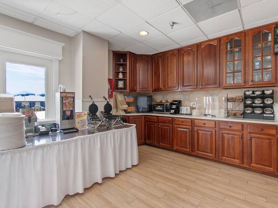 A kitchen with wooden cabinets, a buffet table, and various appliances.