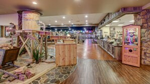 A spacious indoor area with a wooden barrel, a vending machine, and a stone wall.