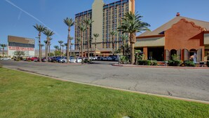 Un hôtel doté d’un grand parking, de palmiers et d’un panneau indiquant le « Laughlin River Lodge ».