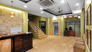 A reception area with a desk, computer, and a staircase. - Hotel Ajanta (New Delhi)