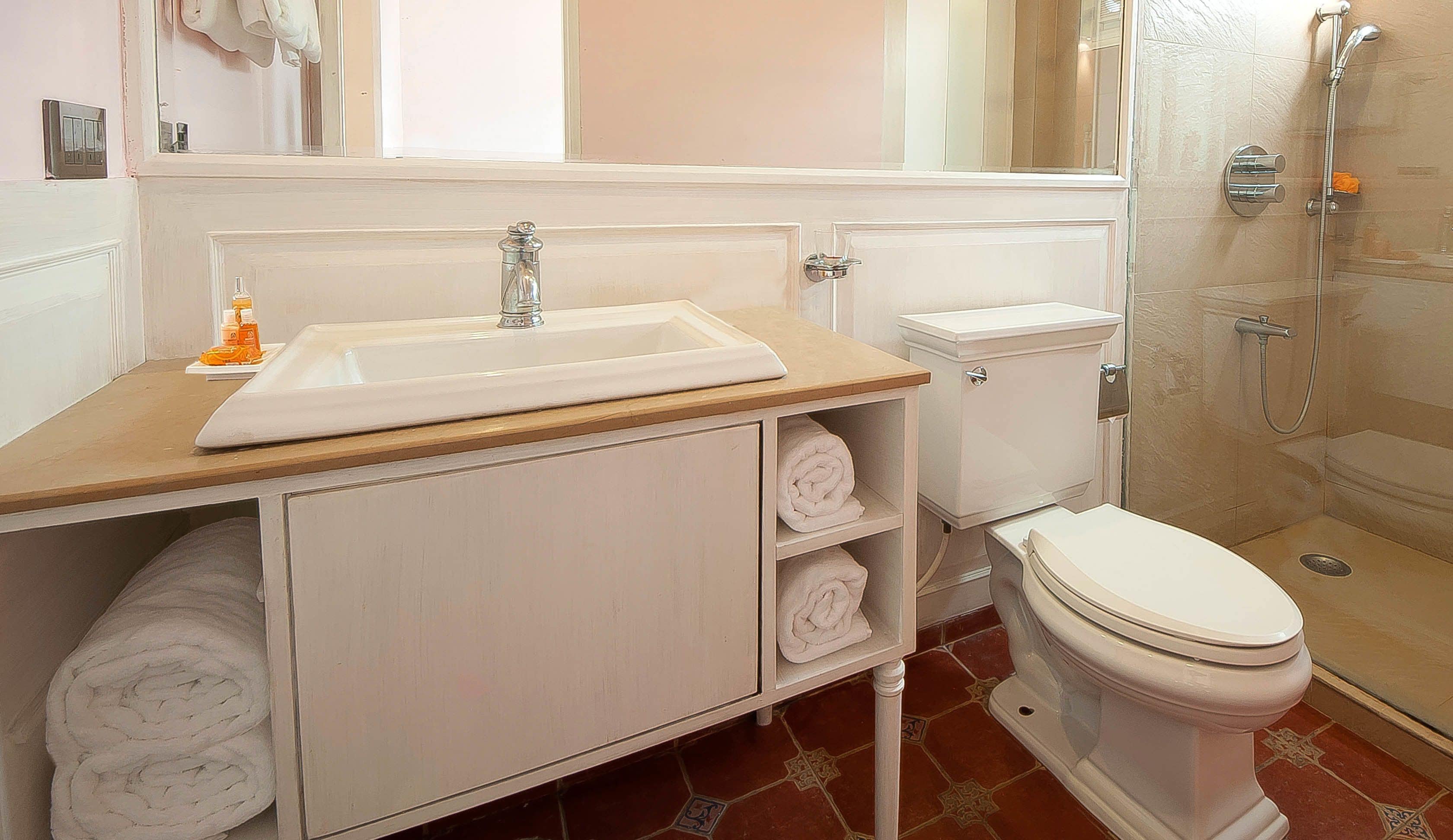 A bathroom with a sink, toilet, and shower.