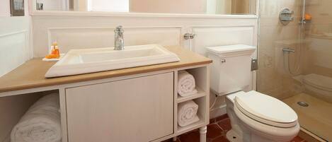 A bathroom with a sink, toilet, and shower.