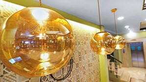Une pièce dotée de luminaires sphériques suspendus et d’un mur orné de motifs.