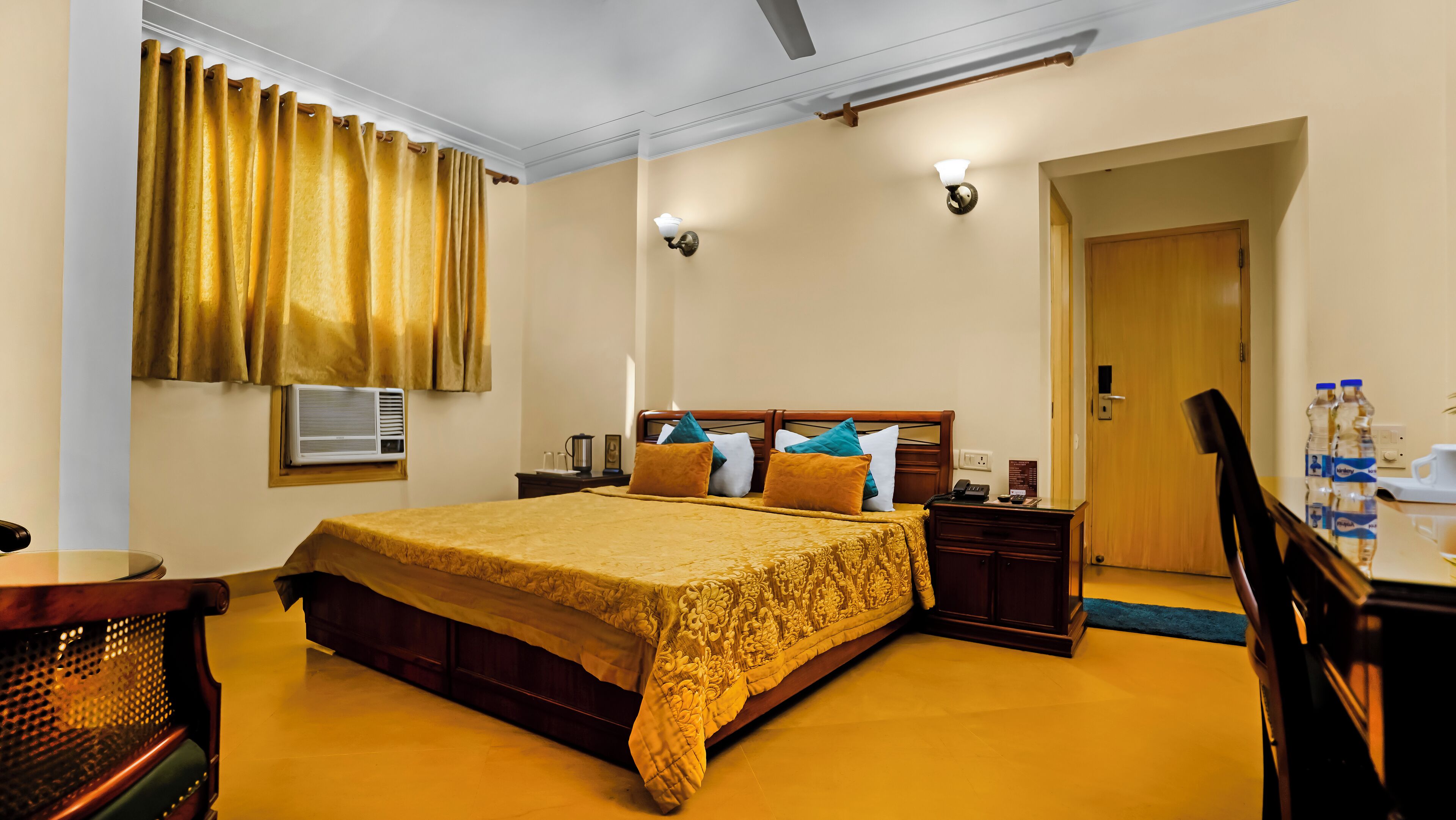 A hotel room with a large bed, bedside tables, a desk, and a chair.