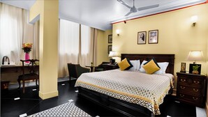Une chambre d’hôtel avec un grand lit, des tables de chevet, un bureau et une chaise.