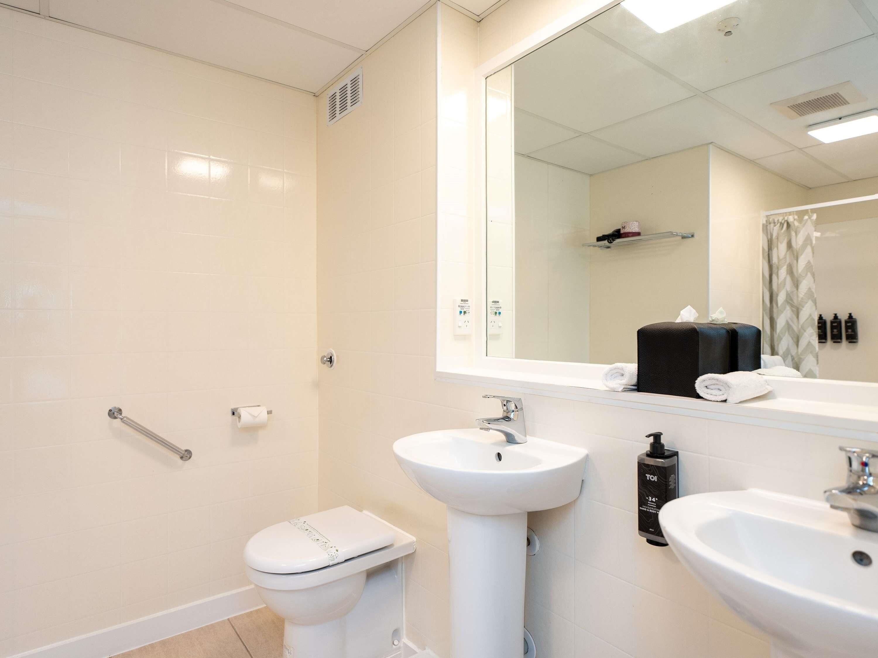 A modern bathroom with a toilet, sink, and shower area.