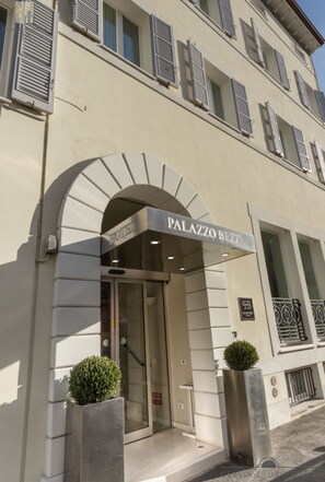 A hotel entrance with a sign reading "PALAZZO BEZZA HOTEL".