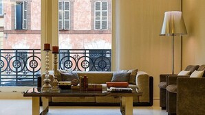 Uma sala de estar com sofá, poltronas, mesa de centro e abajur.
