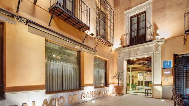 Das Äußere des Palacio de Gamboa, mit einer großen Schautafel, einem Blumentopf und einem barrierefreien Eingang.