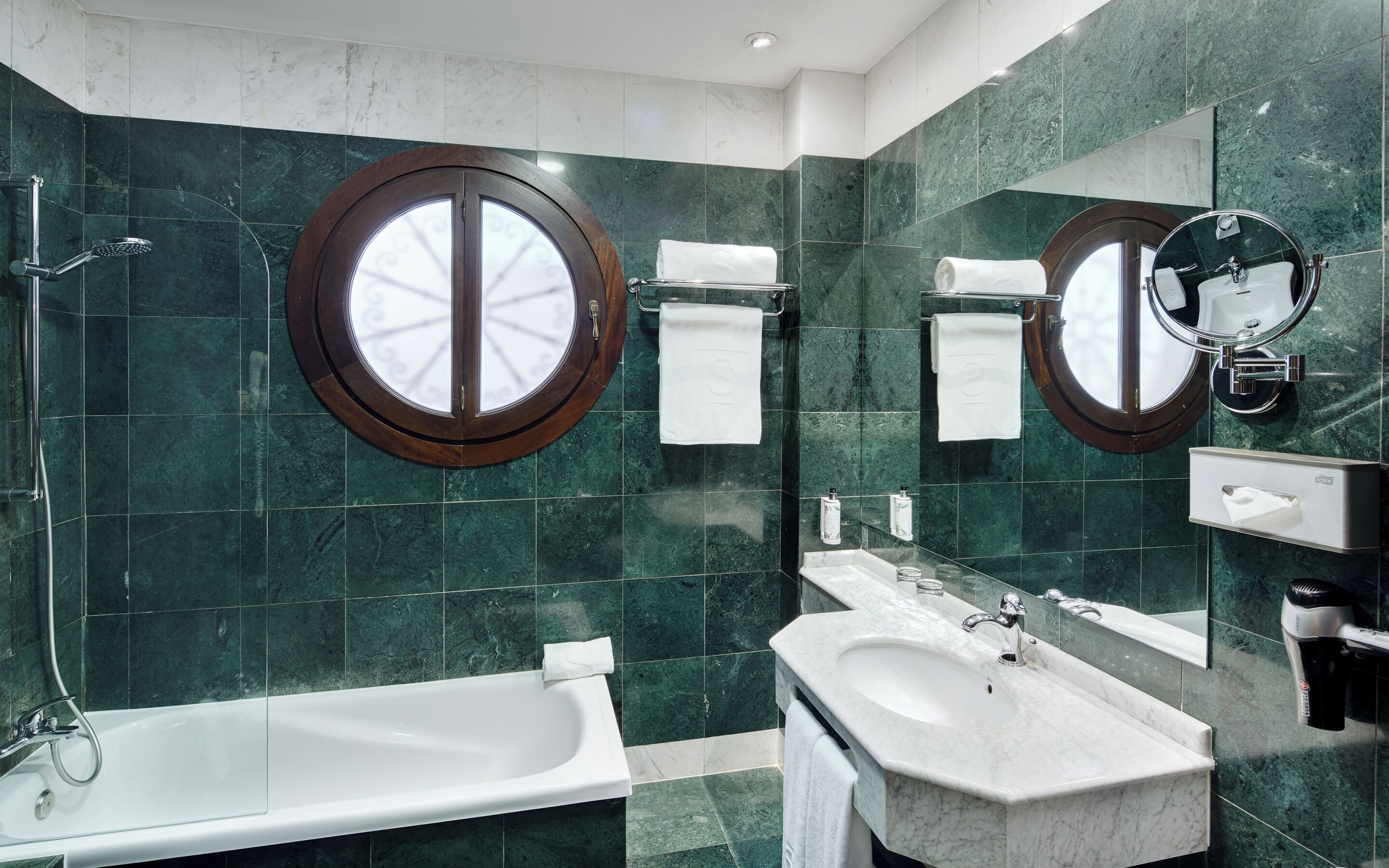 Uma casa de banho moderna com banheira, lavatório e espelho.
