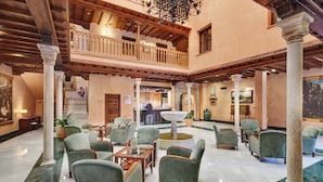 Eine geräumige Lobby mit Springbrunnen, mehreren Sitzbereichen und einem Balkon.