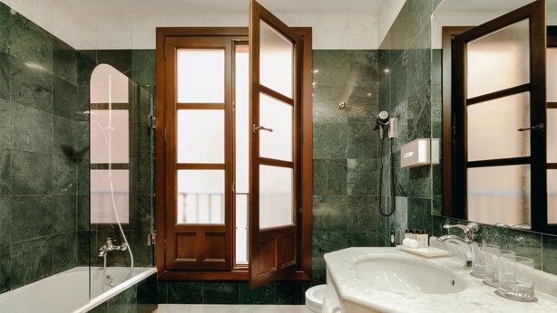 A modern bathroom with a bathtub, a sink, and a shower. - Sercotel Palacio De Los Gamboa (Granada)