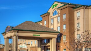 Ein Hotel mit blauem Himmel, einem Schild für 'Holiday Inn Express' und einem Schild mit der Aufschrift 'Clearance 18-3'.