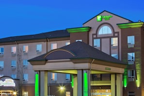 A Holiday Inn & Suites building with a covered entrance and a sign for Seasons on Forty.