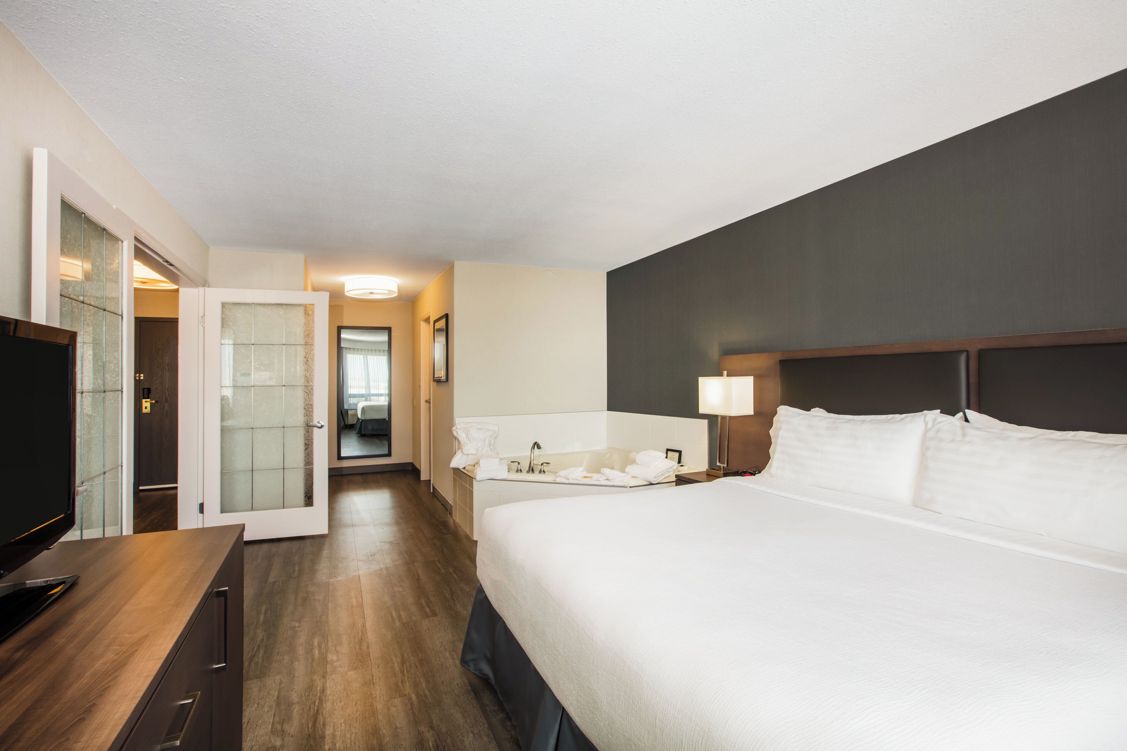 Une chambre d’hôtel avec un lit, un bureau, une télévision et une salle de bain.