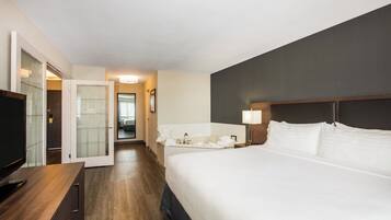 Une chambre d’hôtel avec un lit, un bureau, une télévision et une salle de bain.