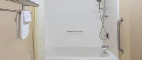 Un área de ducha con bañera, toallero y barra de apoyo.