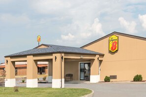 A Super 8 hotel with a covered entrance, a parking lot, and a clear sky. - Super 8 by Wyndham Charleston/Sikeston East MO (Charleston)