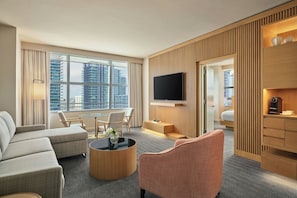 A modern hotel room with a large window, a flat-screen TV, a sofa, a coffee table, and a desk area. - Brickell Arch, a Luxury Collection Hotel, Miami (Miami)