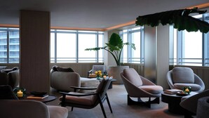 A modern lounge with comfortable seating, large windows, and a potted plant. - Brickell Arch, a Luxury Collection Hotel, Miami (Miami)