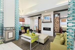 Ein modernes Wohnzimmer mit Kamin, einem Essbereich mit Tisch und Stühlen sowie einer Sitzecke mit einer Couch.