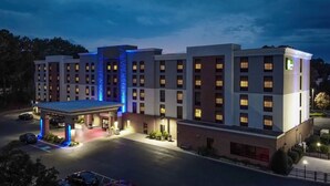 A multi-story hotel with a covered entrance and a parking lot. - Holiday Inn Express & Suites Newport News by IHG (Newport News)