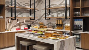 A modern kitchen with marble countertops, wooden shelves, and a wine station.