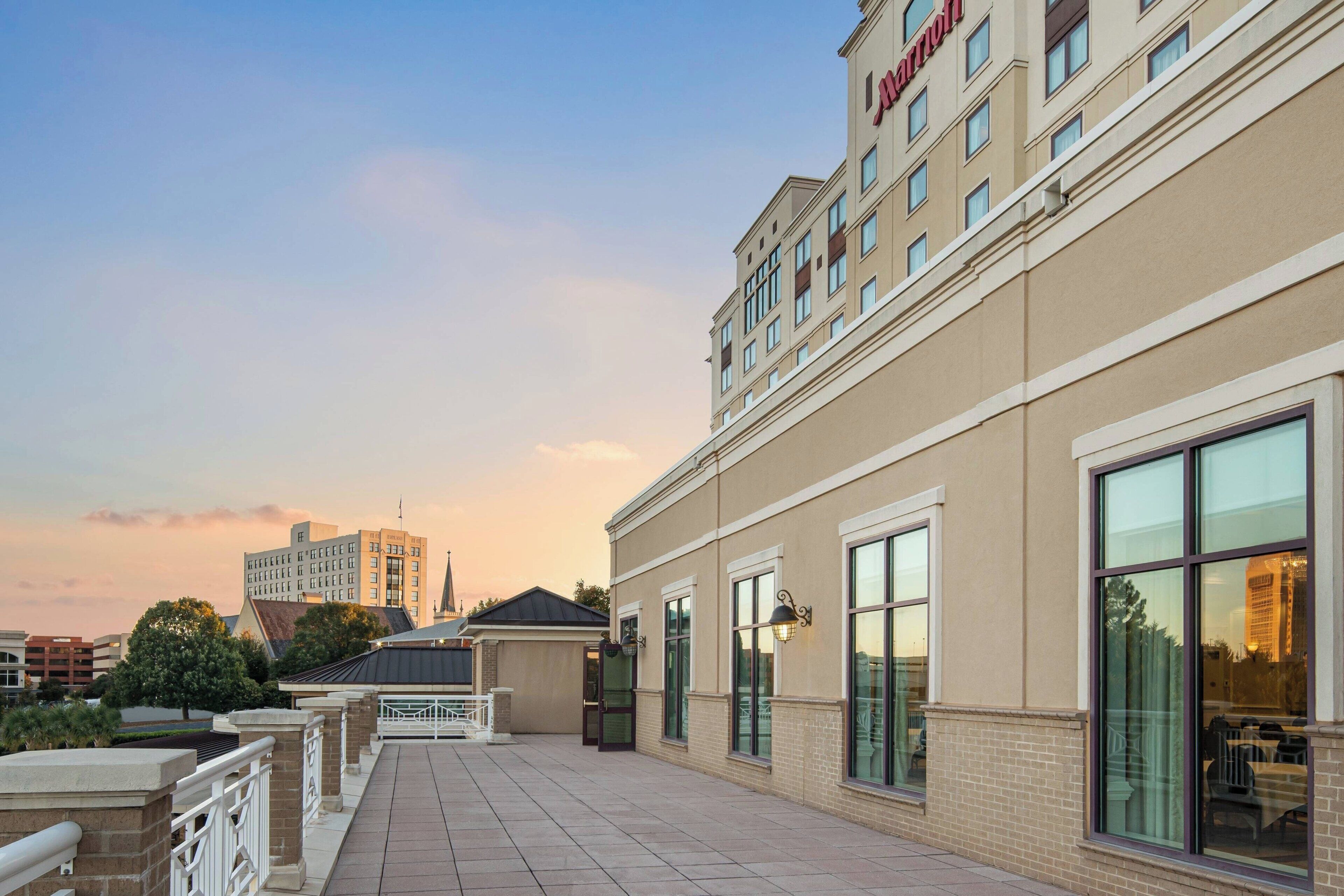 A hotel exterior with a flat roof, large windows, and a brick facade.