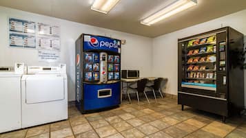 A room with a washing machine, a Pepsi vending machine, and a snack vending machine.