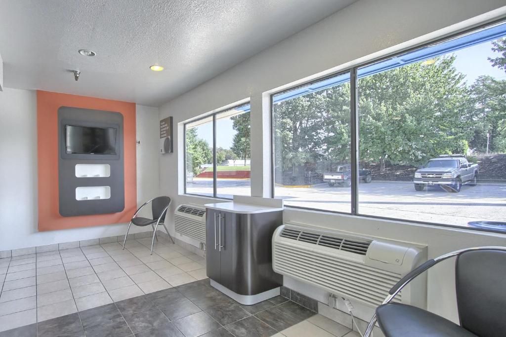 A reception area with a modern design, featuring a large window, a reception desk, and a seating area.