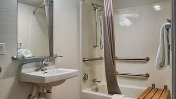 A bathroom with a sink, mirror, shower, and bathtub.