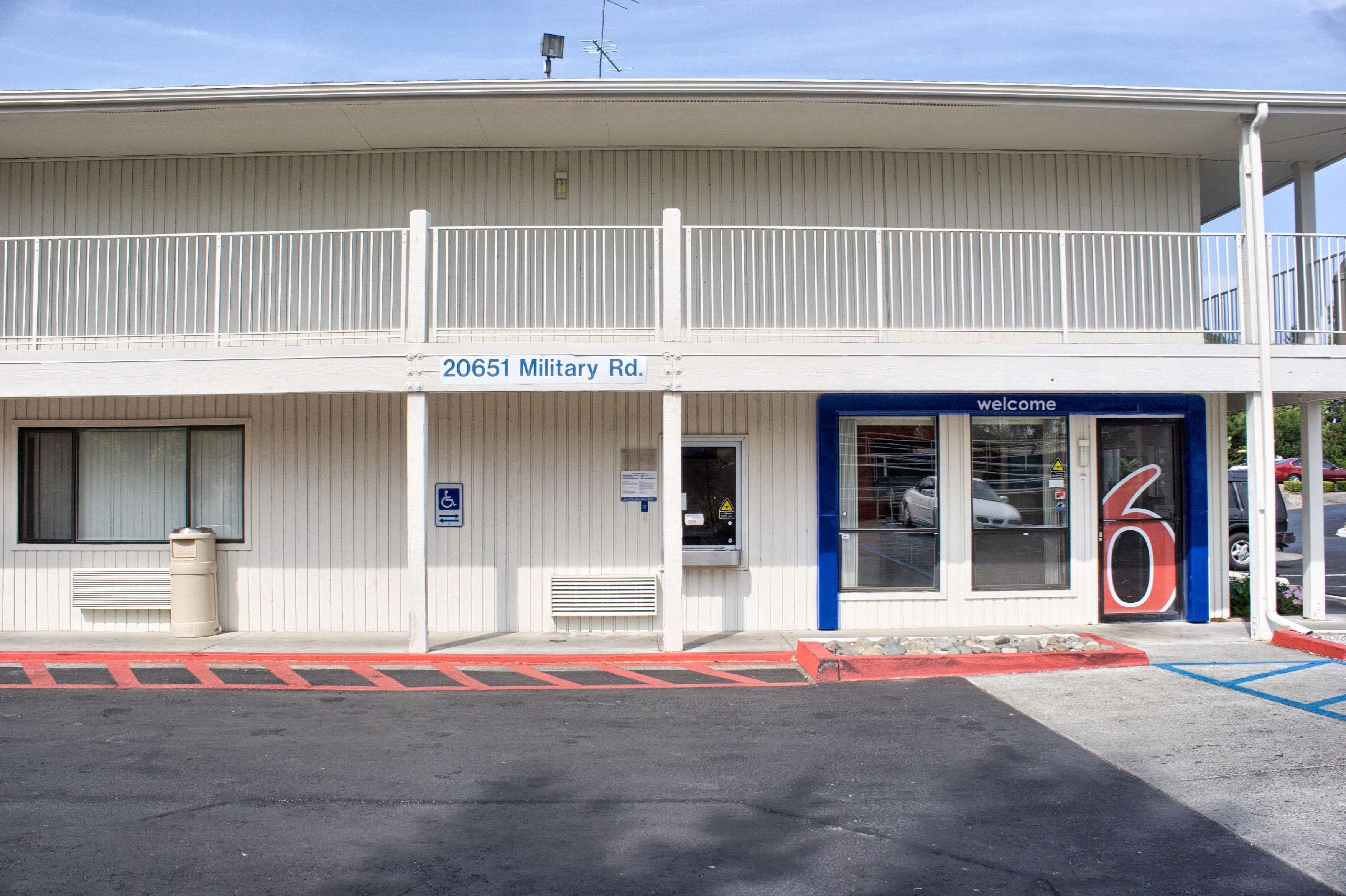 A building with a sign reading "20651 Military Rd." and a blue door with a "welcome" sign.