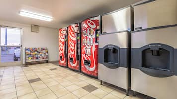 Una hilera de máquinas expendedoras con el logotipo de Coca-Cola, un refrigerador marca Scotsman y una exposición de folletos turísticos.