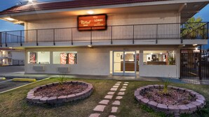 A Red Roof Inn with a balcony, Coca-Cola sign, and a lobby entrance.