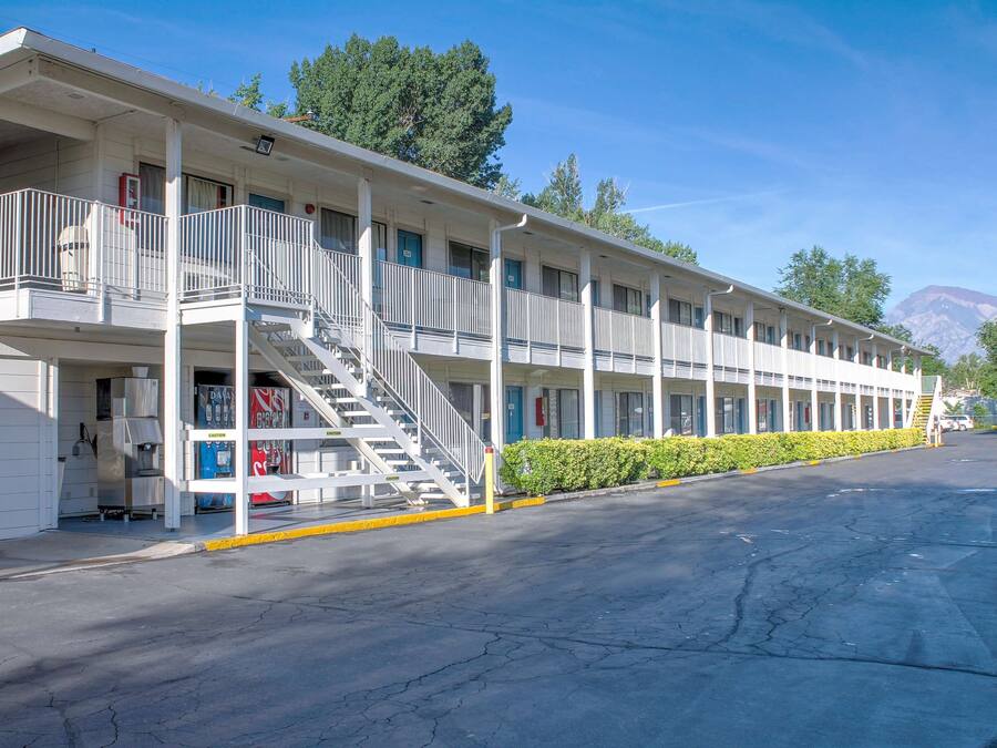 A motel with multiple rooms, a central staircase, and a parking area.