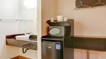 A compact kitchenette with a sink, microwave, and refrigerator.