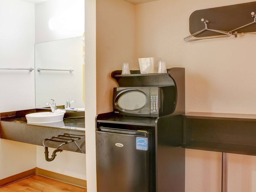 A compact kitchenette with a sink, microwave, and refrigerator.