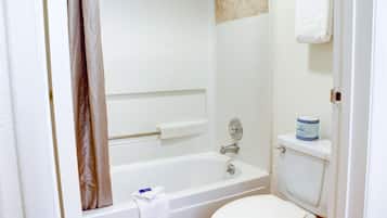 Un baño con bañera, inodoro y toallero.