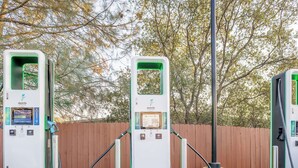 Three electric vehicle charging stations with a wooden fence and trees in the background. - Motel 6 Auburn, CA (Auburn)