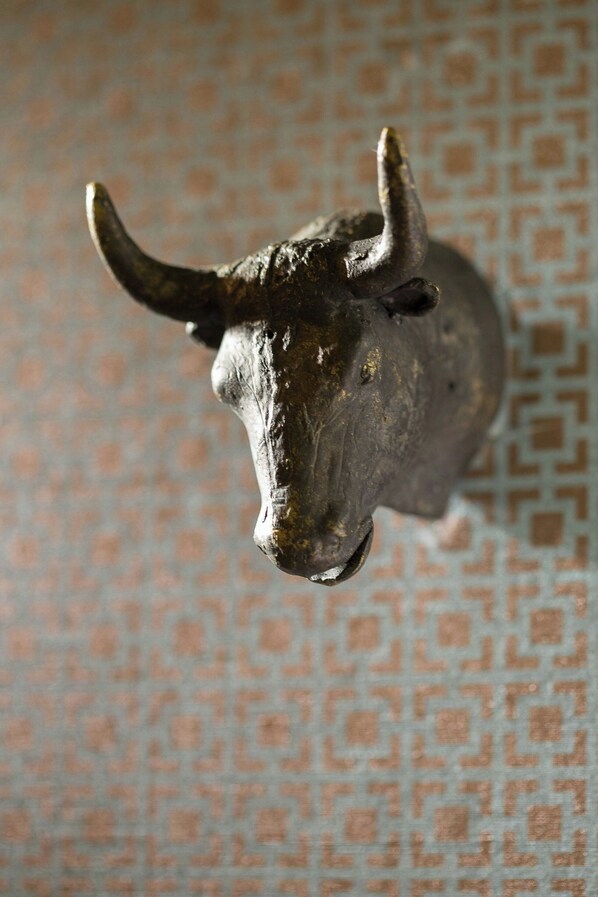 Eine Skulptur eines Stiers an einer Wand befestigt.