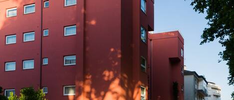 A red building with multiple windows and a covered entrance area.