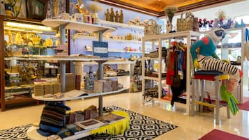 Una boutique bien organizada con estantes que exhiben distintos artículos, un tapete estampado y un peluche colorido.