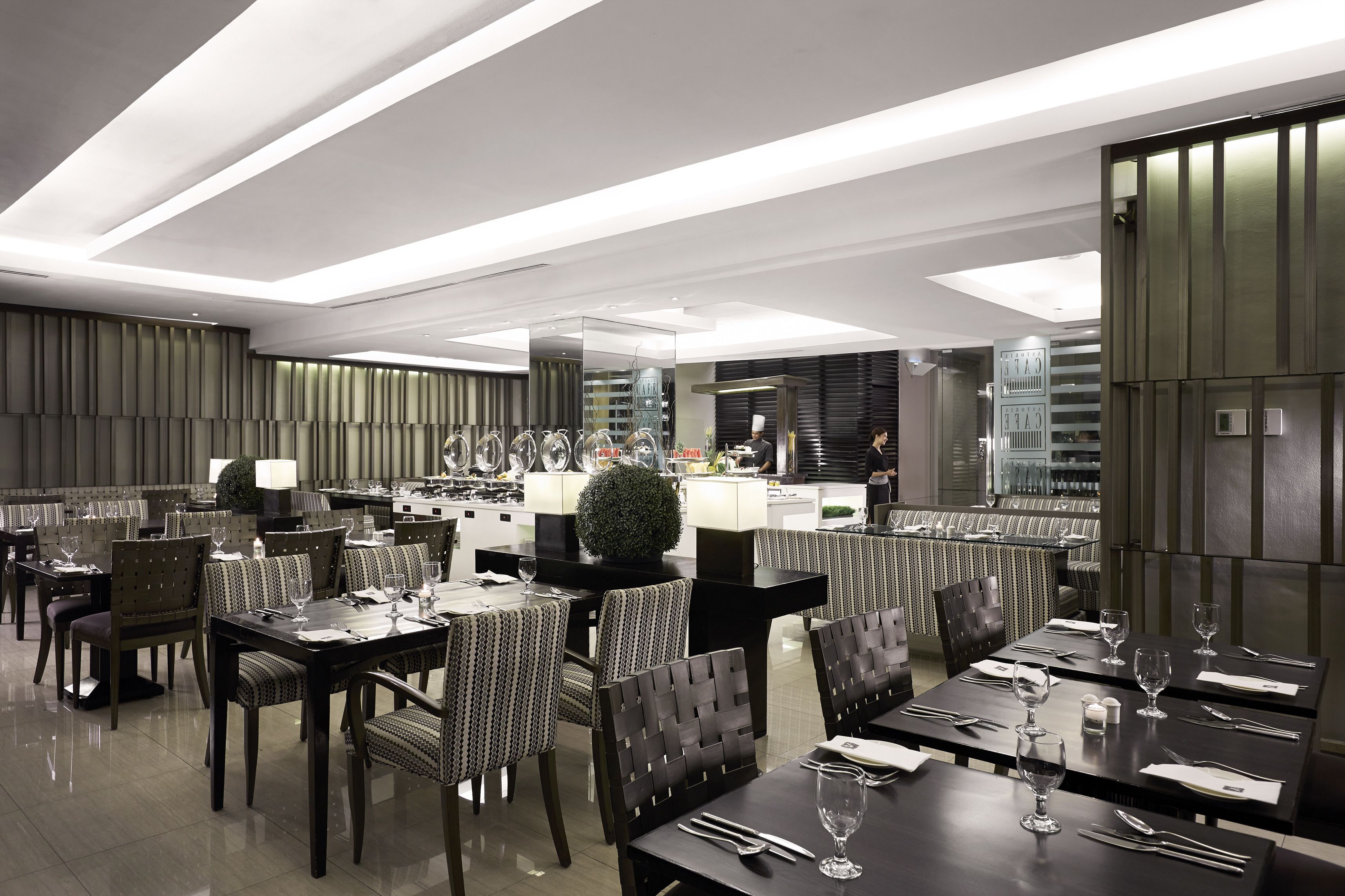 A modern restaurant with multiple dining areas, including a bar and a private dining section.