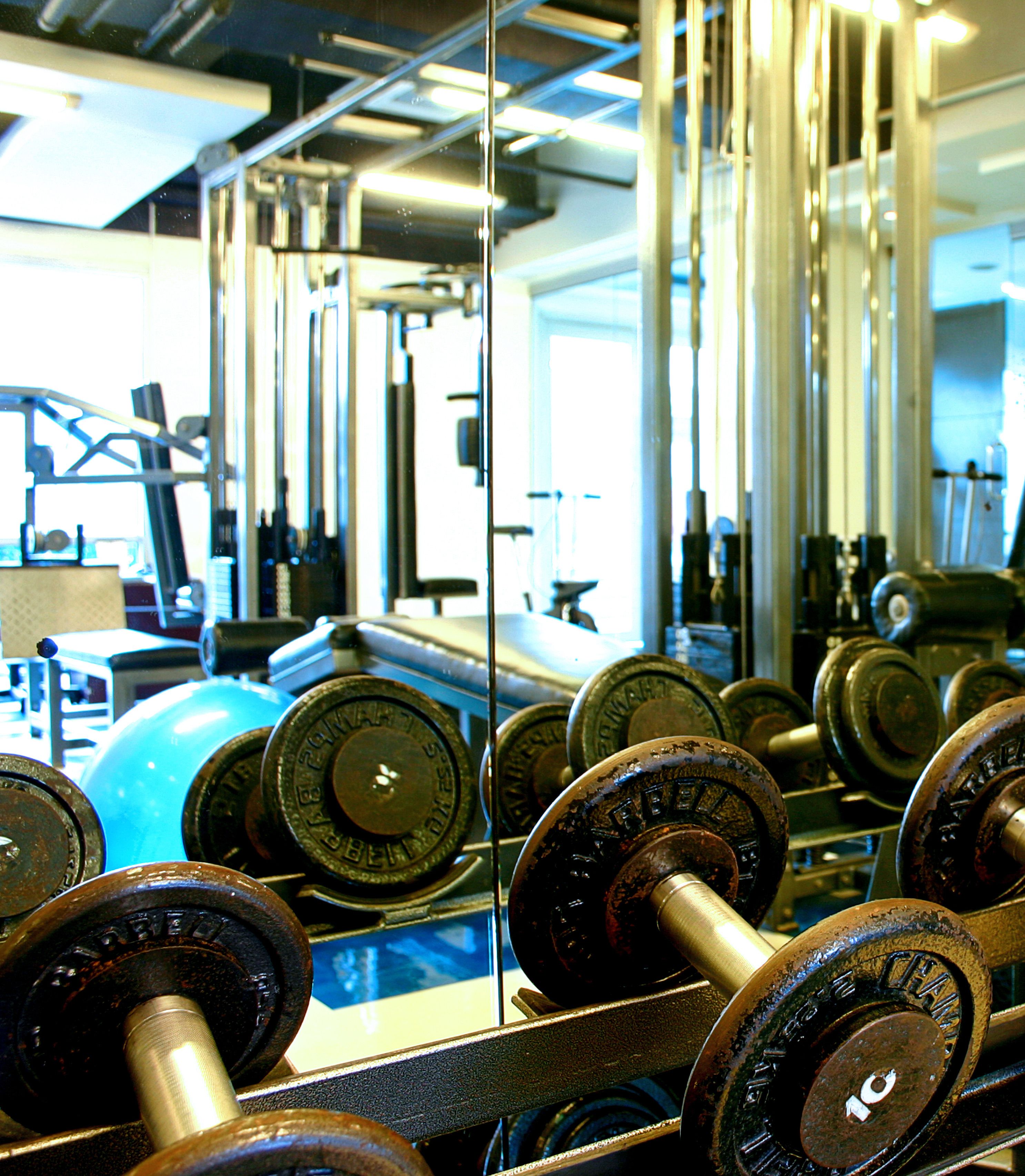 A gym with various exercise equipment, including dumbbells and weight plates.